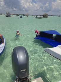 A lively scene of children enjoying the water, with one diving off a blue float and another swimming nearby — perfect for family fun in the sun.