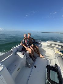 A couple enjoys a sunny day on a boat, capturing a moment of relaxation and togetherness on the water.