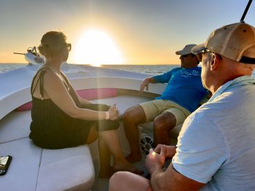 A group enjoys a serene sunset on a boat, creating a perfect atmosphere for relaxation and memorable moments on the water.