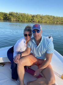 A couple enjoys a moment together on a boat, surrounded by serene waters and lush greenery — perfect for romantic getaways or special celebrations.