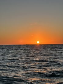 A stunning sunset over the ocean, creating a picturesque backdrop for evening boat trips and romantic cruises.