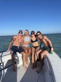 A cheerful group of friends enjoys a sunny day on the boat, capturing the essence of fun and relaxation on the water.