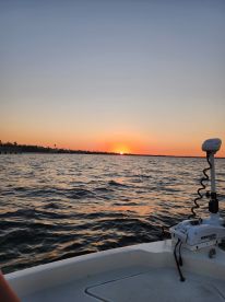 A serene sunset view from a boat, showcasing the tranquil waters and vibrant colors of the evening sky — perfect for peaceful evening cruises.
