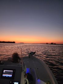 A serene sunset view from the bow of a boat, capturing the tranquil waters and vibrant colors of the evening sky — perfect for romantic outings or peaceful cruises.