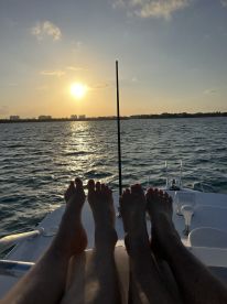 A couple enjoys a serene sunset view from the deck of a yacht, capturing a moment of relaxation and connection on the water.