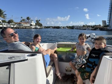 A joyful family enjoys a sunny day on the water, creating lasting memories aboard their boat. Perfect for family outings and adventures.