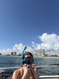 A woman prepares her snorkeling gear on a boat, ready to explore the vibrant underwater world — a perfect adventure for beach lovers and marine enthusiasts.