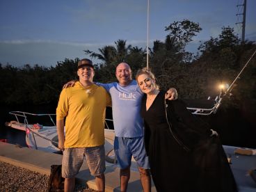 A cheerful group of friends poses together by their boat, capturing a memorable moment of camaraderie and adventure on the water.
