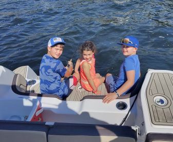 Three children enjoy a fun fishing experience on a boat, creating lasting memories on the water.
