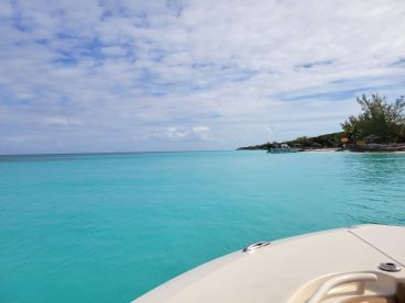 A stunning view of a boat cruising through crystal-clear turquoise waters, showcasing the beauty of the surrounding landscape and inviting adventure on the open sea.