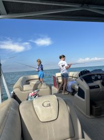 Two children enjoy a fishing trip on a boat, creating memorable family moments on the water.