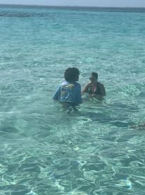 Two individuals enjoy a refreshing swim in crystal-clear waters, showcasing the perfect setting for a fun day on the water.