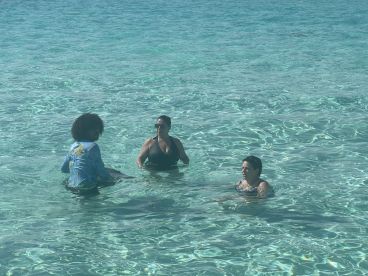 A group of friends enjoys a refreshing swim in crystal-clear waters, capturing the essence of a perfect day on the water.