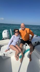 A cheerful couple enjoys a sunny day on a boat, capturing the essence of fun and relaxation on the water.
