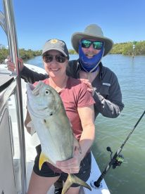A couple proudly displays their catch while fishing on a boat, showcasing a successful day on the water.