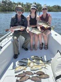A group of three proudly displays their fishing catch aboard a boat, showcasing a successful day on the water. Perfect for fishing enthusiasts and adventure seekers.
