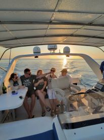 A joyful group celebrates aboard a boat at sunset, capturing the essence of a perfect party on the water.