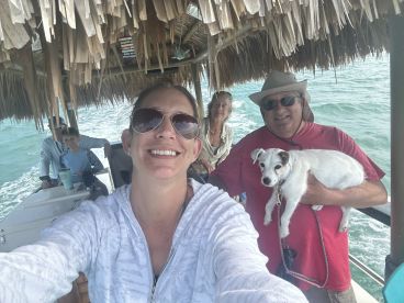 A joyful family enjoys a boat ride together, capturing a fun moment with their dog on board — perfect for family outings and adventures on the water.