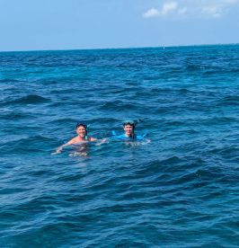 Two friends enjoy snorkeling in vibrant blue waters, capturing the essence of adventure and fun in the sun.