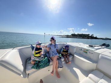 A mother and her two children enjoy a sunny day on the boat, creating cherished family memories while relaxing in the warm weather.