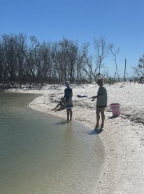 A family enjoys a fishing outing on the beach, with children actively participating in the fun — a perfect way to bond and create lasting memories in the great outdoors.