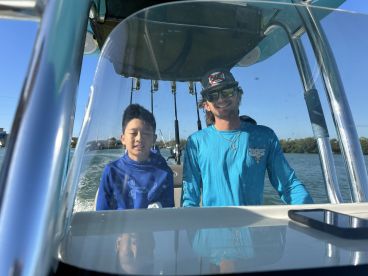 A young boy and a man enjoy a day on the water, showcasing the excitement of boating adventures together.
