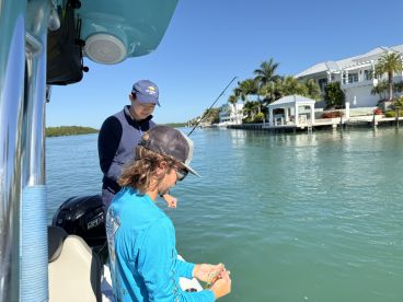 Two friends enjoy a fishing trip on a sunny day, showcasing the perfect blend of relaxation and adventure on the water.