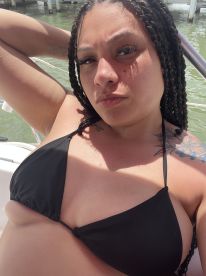 A woman poses on a boat, enjoying the sun and water — a perfect moment for summer fun and relaxation on the water.