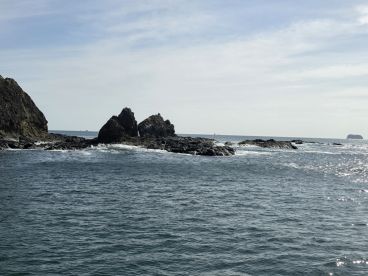 A scenic view of rocky formations emerging from the water, capturing the natural beauty of the coastline.