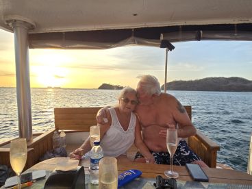 A couple shares a romantic moment with champagne on a boat at sunset, creating the perfect atmosphere for love and celebration on the water.