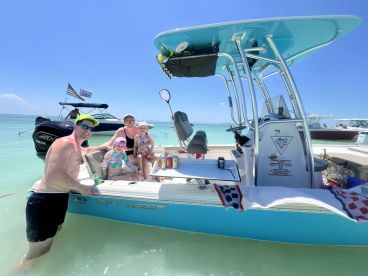 A joyful family enjoys their time on a boat at the beach, capturing fun moments in the sun — perfect for summer adventures and family outings.