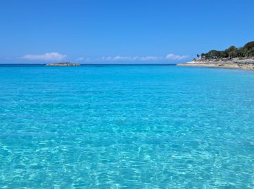 A stunning view of crystal-clear turquoise waters and a serene coastline, perfect for showcasing the beauty of island destinations.