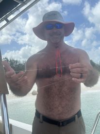 A man demonstrates fishing gear on a boat, showcasing a fun day on the water. Perfect for fishing enthusiasts and adventure seekers.