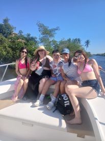 A joyful group of family members enjoys a sunny day on the boat, creating lasting memories together amidst beautiful scenery.