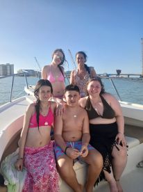 A joyful group of family members enjoys a sunny day on a boat, showcasing the perfect setting for memorable celebrations and family outings on the water.