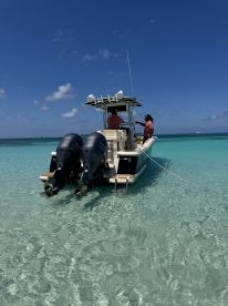Two individuals enjoy a sunny day aboard a boat in crystal-clear waters, showcasing the perfect setting for a day of adventure and relaxation.