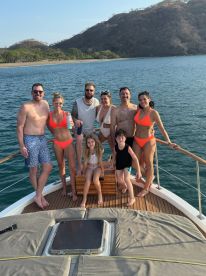 A joyful group of friends and family pose together on the deck of a boat, enjoying a sunny day on the water — perfect for memorable celebrations and family outings.