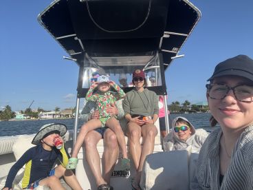 A joyful family enjoys a sunny day on the boat, creating lasting memories together. Perfect for family outings and adventures on the water.