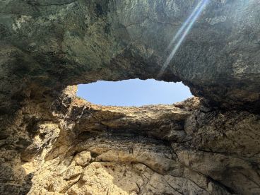 An abstract view of a rocky formation with a hole, capturing the natural textures and colors of the stone.