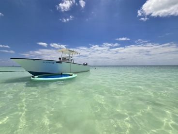 A sleek boat anchored in clear turquoise waters, showcasing a perfect day for boating adventures under a bright blue sky.