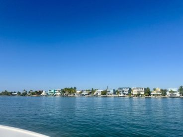 A picturesque view of colorful waterfront homes along a serene coastline, perfect for showcasing the beauty of a boating trip.
