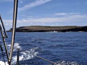 A scenic view of a rugged coastline from a boat, showcasing the beautiful ocean and island landscape — perfect for nature lovers and adventure seekers.