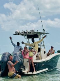 A joyful group poses on a boat, with some ready for snorkeling, capturing the essence of family fun on the water.