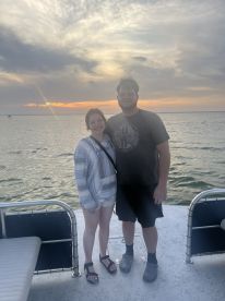 A couple poses together on a boat at sunset, capturing a memorable moment on the water — perfect for romantic outings or special celebrations.
