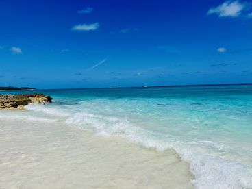 A stunning view of a pristine beach with turquoise waters and gentle waves, perfect for a relaxing getaway or beach day.