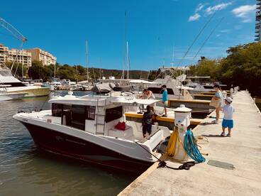 A family enjoys a day at the marina, with children exploring the dock and boats, creating memorable moments by the water.