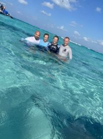 A group of friends enjoys a fun snorkeling experience in crystal-clear waters, capturing a memorable moment in the sun.