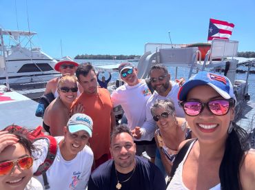 A joyful group poses for a selfie on a boat in Puerto Rico, capturing the essence of fun and camaraderie during their aquatic adventure.