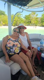 A happy couple enjoys a relaxing moment on a boat, surrounded by beautiful scenery — perfect for a sunny vacation getaway.