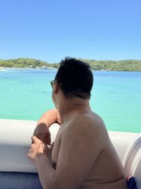 A person enjoys a serene view of turquoise waters while relaxing on a boat, capturing the essence of a perfect day on the water.